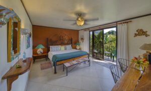 Guest room at a Costa Rica investment property with comfortable furnishings, garden views, and tropical décor.
